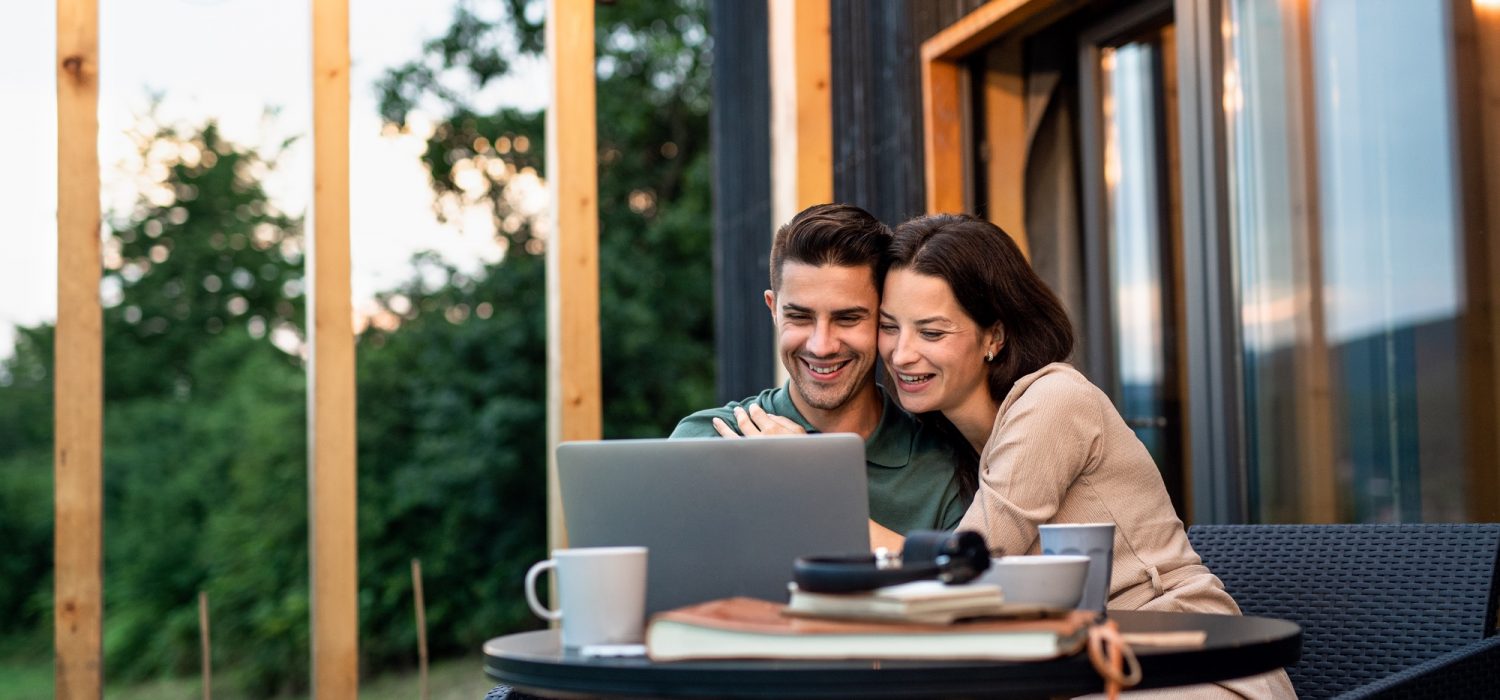 couple using laptop and enjoying at their backyard